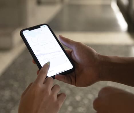 A person uses a car rental app at an airport