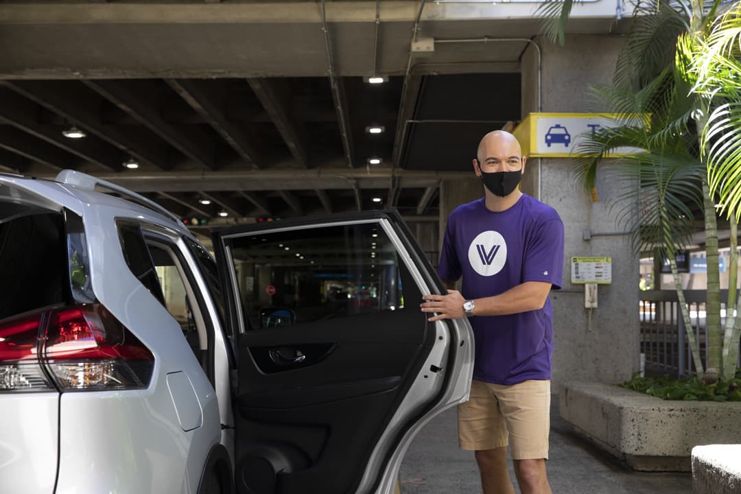 A GoVibe driver opens the door of a car rental