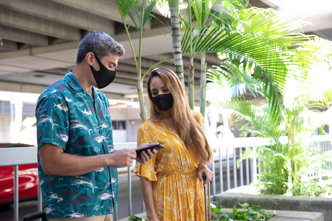 Two tourists in Hawaii book their rental car on the GoVibe app.