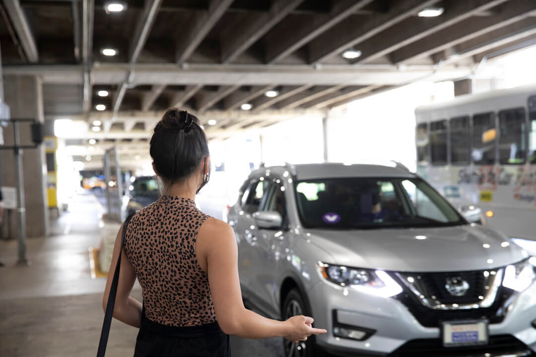 A GoVibe Member looks on as her rental car arrives