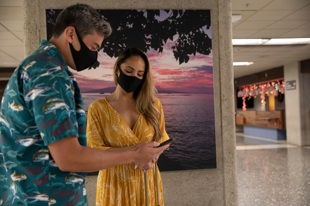 Two cruise passengers browse car rentals on a phone